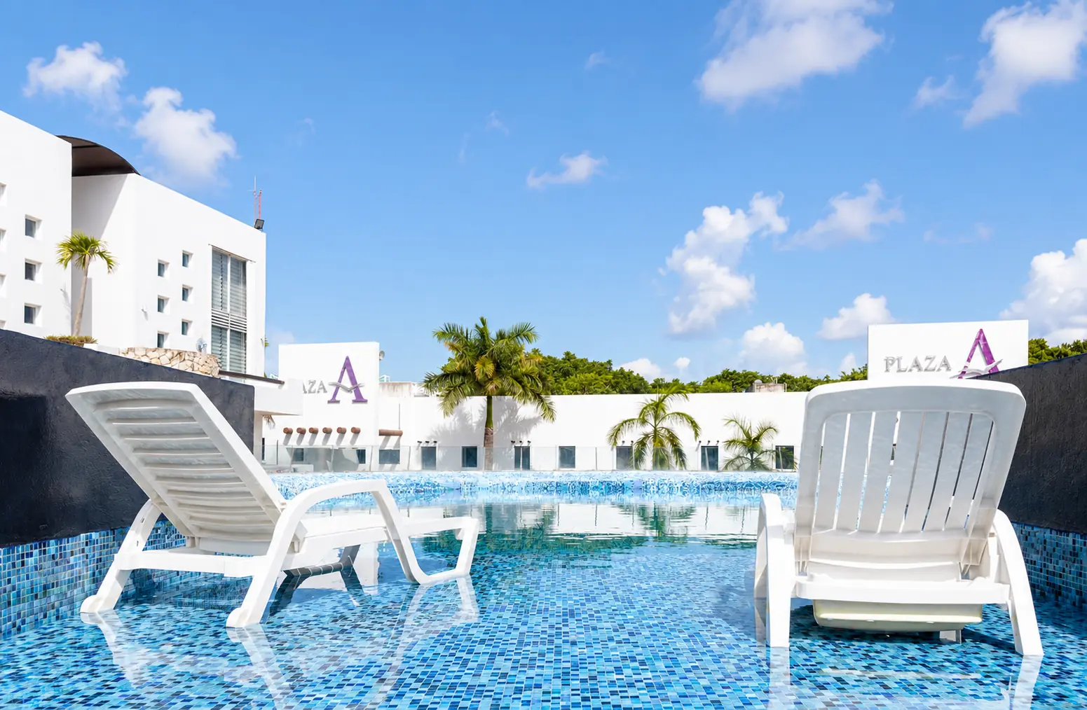 Alberca y asoleadero del desarrollo en Playa del Carmen